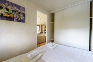 a bedroom with a large white bed with towels on it at Prachtige vakantiewoning aan water met grote tuin in Voorthuizen