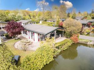 an aerial view of a house with a pond at Prachtige vakantiewoning aan water met grote tuin in Voorthuizen