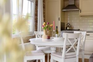 a kitchen with a white table and white chairs at Prachtige vakantiewoning aan water met grote tuin in Voorthuizen +31 photos