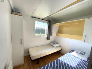Kleines Zimmer mit einem Bett und einem Fenster in der Unterkunft Chalet situé dans un camping 4 étoiles - 4 à 6 personnes - KIRIO in Guidel