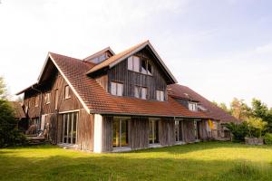 une grande maison en bois avec un toit en gambrel dans l'établissement Stadt Land Freunde, à Wangen im Allgäu