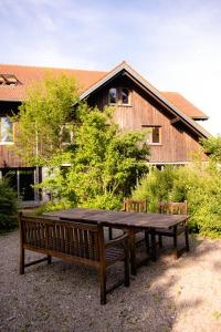 une table en bois et des bancs devant un bâtiment dans l'établissement Stadt Land Freunde, à Wangen im Allgäu