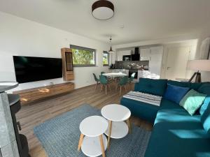a living room with a blue couch and a kitchen at The Fehmarn Lodges - RELAX - in Fehmarn