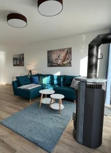 a living room with a blue couch and a fireplace at The Fehmarn Lodges - RELAX - in Fehmarn