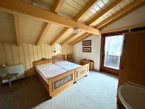 um quarto com uma cama num quarto com uma janela em Ferienwohnung Bergtraum - Chiemgau Karte em Inzell