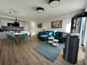 a living room with a blue couch and a fireplace at The Fehmarn Lodges - OASIS - in Fehmarn