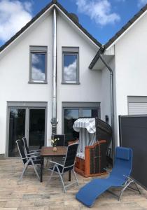 a house with a patio with chairs and a table at The Fehmarn Lodges - OASIS - in Fehmarn