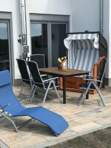 a wooden table and chairs on a patio at The Fehmarn Lodges - OASIS - in Fehmarn