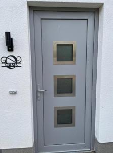 a white door with two windows on a building at The Fehmarn Lodges - OASIS - in Fehmarn