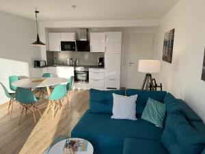 a living room with a blue couch and a table at The Fehmarn Lodges - OASIS - in Fehmarn