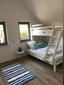 a bedroom with a bunk bed and a rug at The Fehmarn Lodges - EMOTION - in Fehmarn +17 photos
