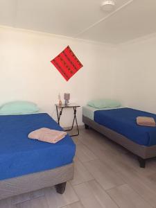 2 camas en una habitación con mesa en Misky Wasi en San Pedro de Atacama
