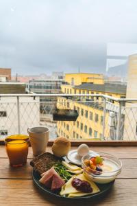 オーフスにあるダンホステルズ オーフス シティの景色を望むテーブルの上に朝食用の食材を並べたもの