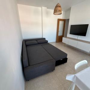 a bedroom with a bed and a flat screen tv at Apartamento en el Grao de Gandía in Gandía