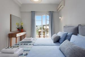a bedroom with a large bed with a window at Marietta's Resort by Konnect, Gouvia Corfu in Gouvia