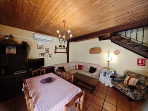 uma sala de estar com uma mesa e um sofá em Casa Rural TioMoreno by Naturadrada em La Adrada