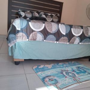- un lit superposé avec un couvre-lit bleu et un tapis dans l'établissement Sandton guesthouse, 