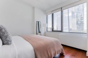 um quarto branco com uma cama e uma grande janela em Blueground Hudson Yards sports fitness wd NYC-1484 em Nova York