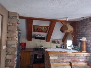 - une cuisine avec un mur en briques et une cuisinière dans l'établissement Loft 'PRL', à Tykocin