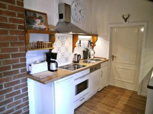a kitchen with white appliances and a brick wall at Welcome Home + Terrasse in Winterberg
