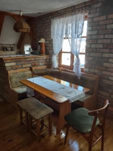 stół i krzesła w kuchni z ceglaną ścianą w obiekcie Loft 'PRL' w Tykocinie