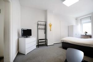 um quarto com uma cama e uma televisão numa cómoda em Wendelin em Sankt Wendel