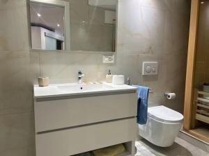 a bathroom with a white sink and a toilet at Palm Beach apartment Bissone in Bissone +11 photos