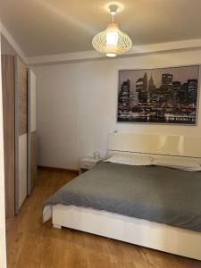 Un dormitorio con una cama y un cuadro en la pared. en Palm Beach apartment Bissone, en Bissone