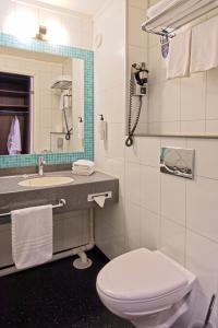 ein Badezimmer mit einem WC, einem Waschbecken und einem Spiegel in der Unterkunft Radisson Blu Polar Hotel, Spitsbergen in Longyearbyen
