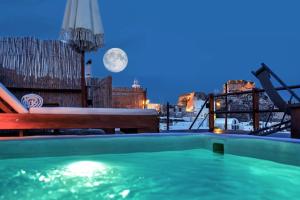 a swimming pool with a full moon in the background at Santorini Rooftop Hot Tub Suite with Panoramic Views in Akrotiri