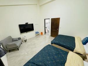 a room with a bed and a couch and a tv at 希玥海邊 包棟民宿 in Wujie