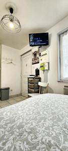 a room with a large bed and a tv on the wall at Studio avec wifi a Montargis in Montargis