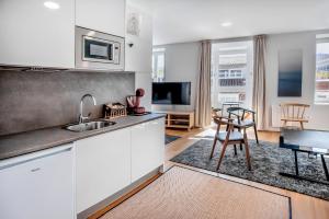 a kitchen with white cabinets and a sink and a table at SNÖ HOTEL CAMINO do EUME APARTAMENTOS in Puentedeume