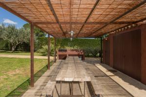 una mesa de picnic de madera bajo una pérgola de madera en Flateli Corçà, en Corçà