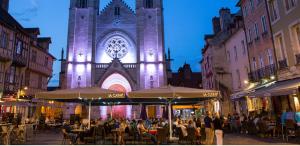 a group of people sitting at tables in front of a building at L'appart Saint-Laurent in Chalon-sur-Saône