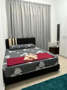 a bedroom with a bed with a red blanket on it at Homestay Angah in Melaka