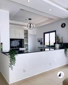 uma cozinha com um balcão branco num quarto em Residence P em Kribi