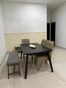 a black table and chairs with a napkin on it at Homestay Angah in Melaka