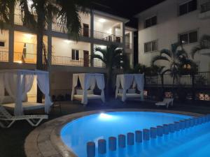 ein Pool vor einem Hotel in der Nacht in der Unterkunft Stunning 1-Bed Apartment pool view in Punta Cana in Punta Cana