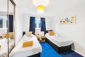 um quarto com duas camas e um espelho em Premier - Maryhill Apartment em Glasgow