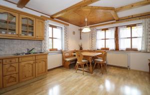 una cucina con armadi in legno, tavolo e sedie di Amazing Home In Puchbeihallein With Wifi a Puch bei Hallein