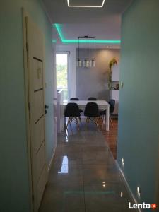 a dining room with a table and chairs and a green light at Najlepszy Apartament Sikorskiego in Olsztyn