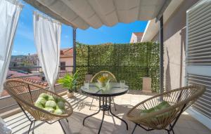 een patio met een tafel en stoelen op een balkon bij Amazing Apartment In Vela Luka With Kitchen in Vela Luka