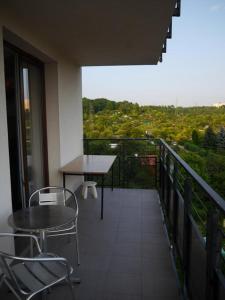 a balcony with a table and chairs and a view at Najlepszy Apartament Sikorskiego in Olsztyn