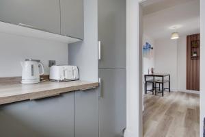 una cucina con armadi bianchi e piano di lavoro di Wimbourne Road Apartment 2 a Bournemouth