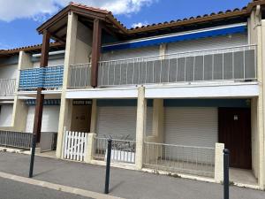 un edificio con dos puertas de garaje y una valla en Appartement Fleury-Saint-Pierre-la-Mer, 1 pièce, 2 personnes - FR-1-229D-232, en Saint Pierre La Mer