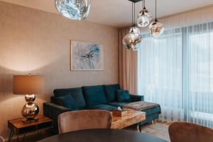 un soggiorno con divano blu e tavolo di MOLO LIPNO RESIDENCE a Lipno nad Vltavou