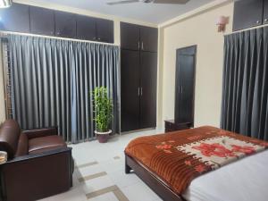 a bedroom with a bed and a chair in it at Allegro Suites, Cox's Bazar in Cox's Bazar