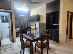 a kitchen with a table and chairs and a refrigerator at Allegro Suites, Cox's Bazar in Cox's Bazar