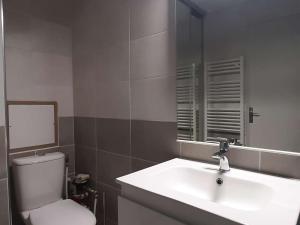 a bathroom with a sink and a toilet and a mirror at Appartement Montgenèvre, 1 pièce, 2 personnes - FR-1-330D-1 in Montgenèvre